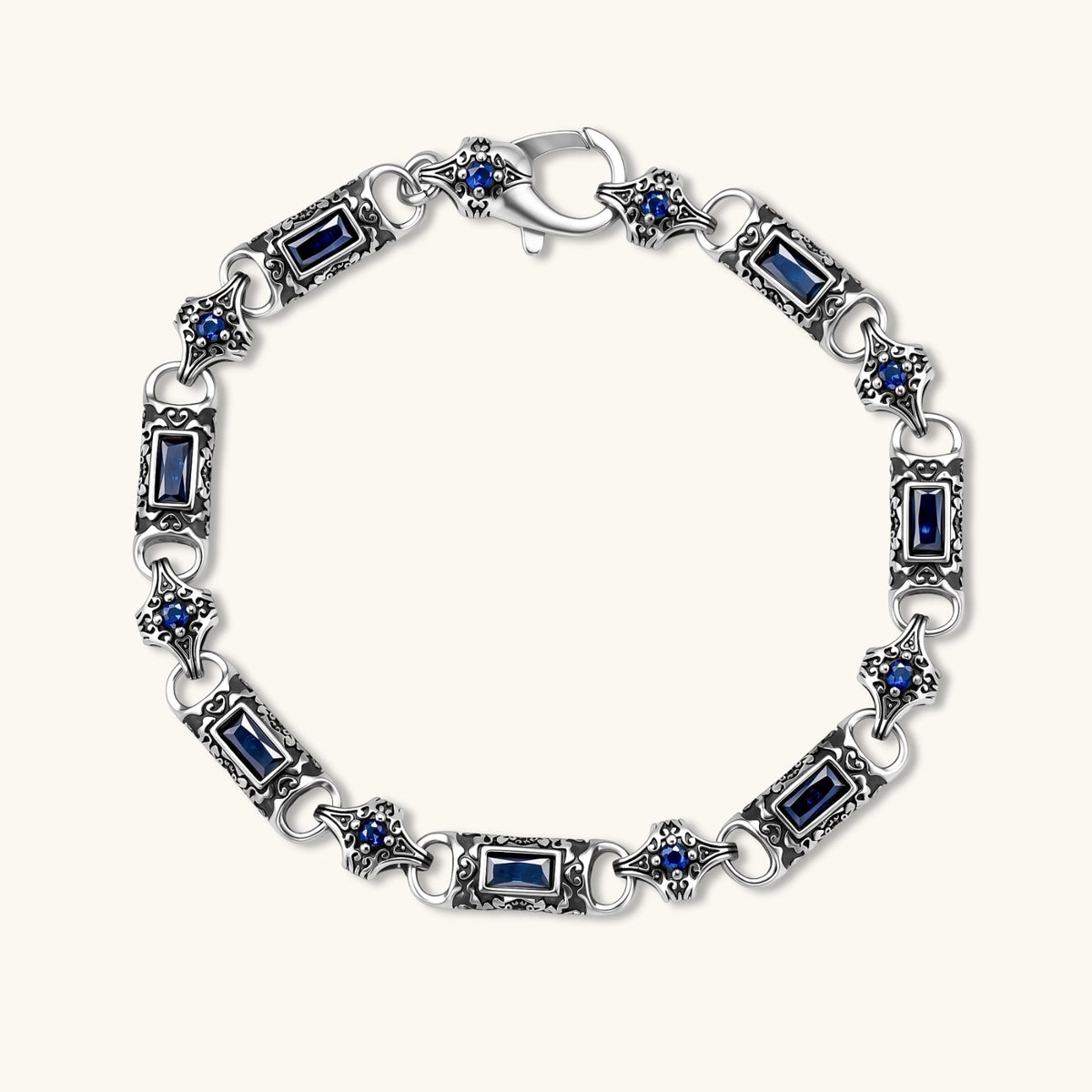 Oxidized silver stainless steel link bracelet with baguette blue CZ stones and intricate scroll engravings, lobster clasp.