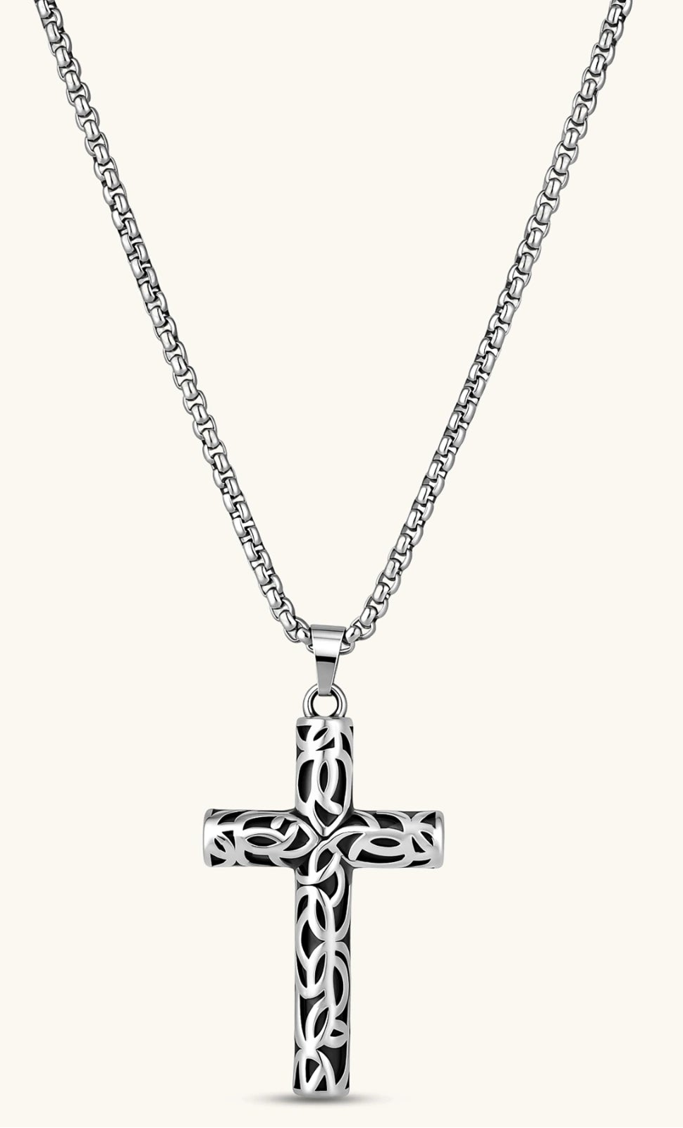 Silver stainless steel Celtic cross pendant with filigree vine pattern on a box chain, against a cream background.