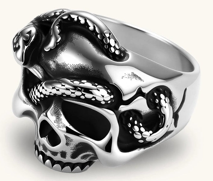Silver stainless steel ring with bold skull face and coiled snake wrapping the crown, blackened recessed details.
