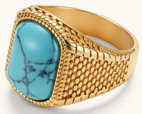 Gold PVD stainless steel signet ring with cushion faux turquoise stone and textured honeycomb band, front view.